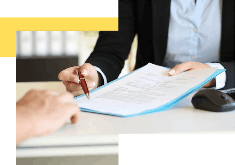 A person is signing papers at a table